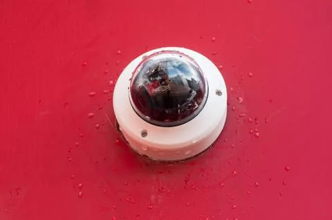 Security camera on red wall background Stock Photos
