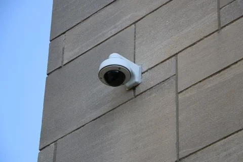 Security camera on stone building wall Stock Photos