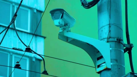 Security camera surveillance mounted on urban pole against bright facade Stock Footage 341969519