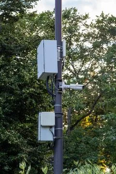 Security camera system with control boxes mounted on a metal pole against Stock Photos