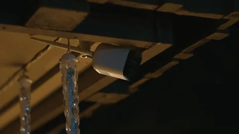 Security camera under roof at night next to decorative lights Stock Footage 333678894