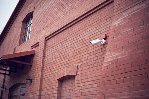 Security camera on the wall of a brick building Stock Photos