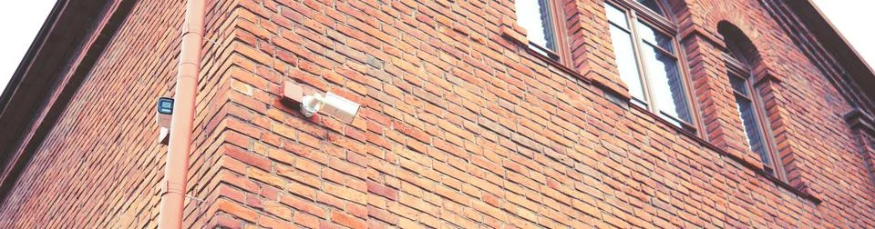 Security camera on the wall of a brick building Stock Photos