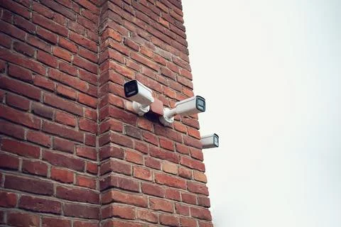 Security camera on the wall of a brick building Stock Photos
