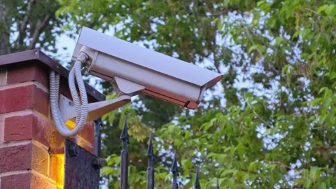 Security camera on the wall. Security camera scanning the street in city. Stock Footage 310719358