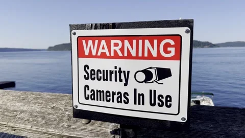 Security camera warning sign on waterfront pier Stock Footage 336878413