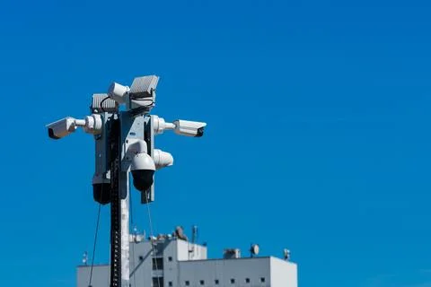 Security cameras installed on a pole against a clear blue sky Stock Photos
