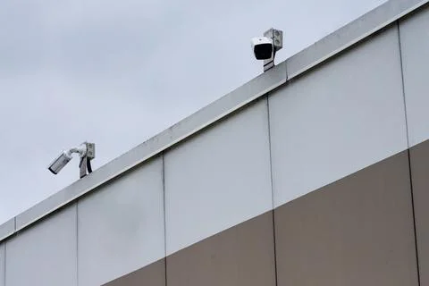 Security cameras installed on top of modern building wall Stock Photos