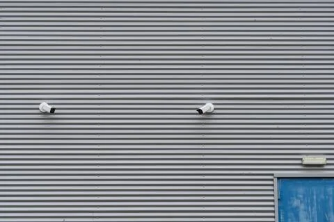 Security cameras on the outside of a warehouse wall. Foto stock