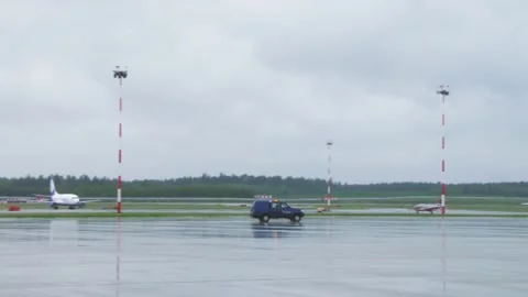 Security car with flashing lights is driving in the background. Airplane parked Stock Footage 138830826