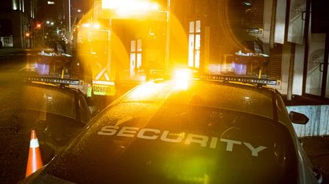 Security car patroling at construction site at night  city Stock Photos