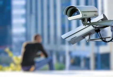 Security CCTV camera or surveillance system with young man on blurry backgrou Stock Photos