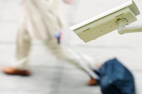 Security CCTV camera or surveillance system with business man walking on blur Stock Photos