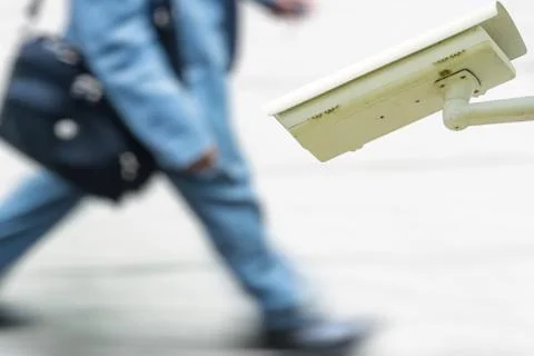Security CCTV camera or surveillance system with business man walking on blur Stock Photos