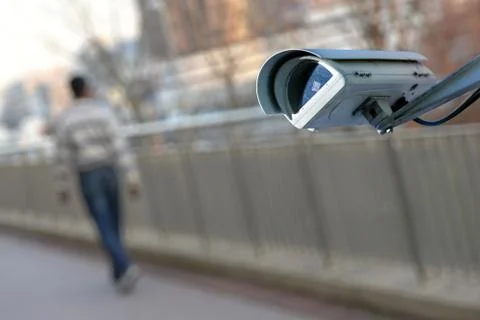 Security CCTV camera or surveillance system with man on blurry background Stock Photos