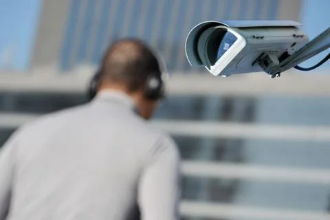 Security CCTV camera or surveillance system with man on blurry background Stock Photos