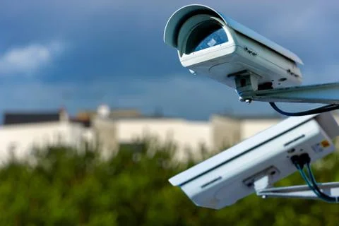 Security CCTV camera or surveillance system with residential dwellings on blu Stock Photos