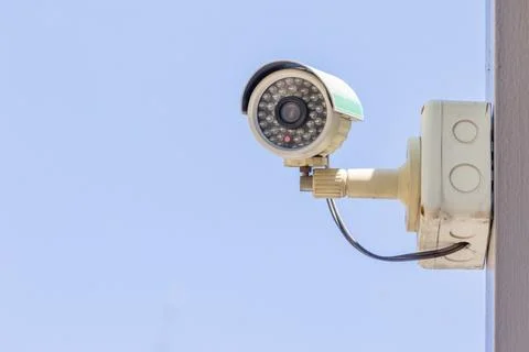 Security CCTV camera or surveillance system in office building on blue sky .. Stock Photos