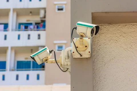 Security CCTV camera or surveillance system in office building on blue sky .. Stock Photos