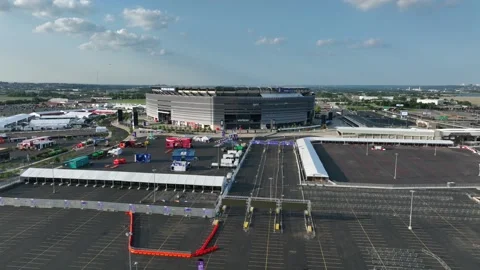 Security checkpoints and vendor tents fill spacious parking lot outside MetLife Stock Footage 340322568