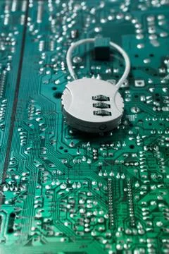 Security cipher padlock on computer circuit board. Stock Photos