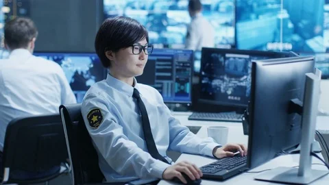 In the Security Command Center Officer at His Workstation Monitors Screens. Stock Footage 81020785