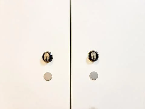 Security cylinder locks on white cabinet doors Stock Photos