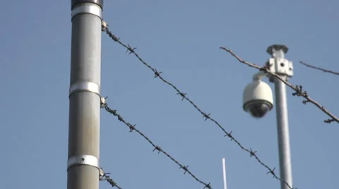 Security dome camera behind barbed wire fence Stock Footage 36621082