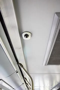 Security dome camera installed on the ceiling inside a public transport vehicle Stock Photos