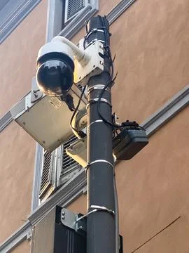 Security dome camera mounted on a utility pole overlooking urban street, pr.. Stock Photos
