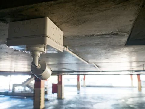 Security equipment concept. Closeup CCTV camera monitoring in the cars park. Stock Photos