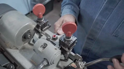 Security expert man meticulously working on a duplicate key. Lock repair Stock Footage 276872214
