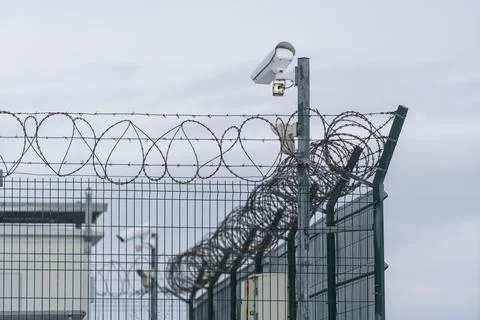 Security features at a high-security facility with barbed wire and surveill.. Stock Photos