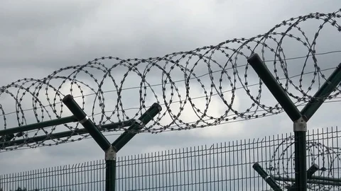 Security fence with a barbed wire with grey sky. Stock Footage 79032084