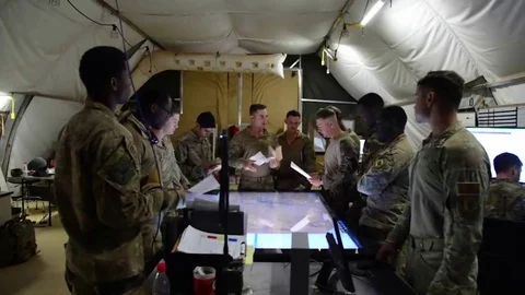 Security Forces soldiers hold intelligence briefing in base camp tent in Nigeria Stock Footage 85019379