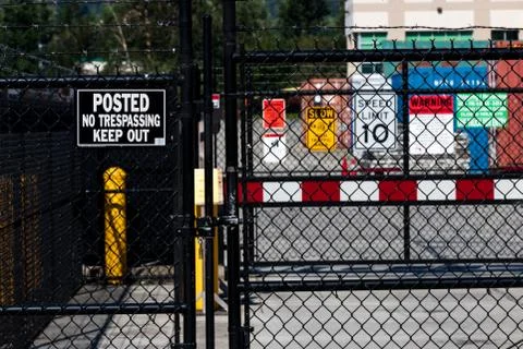 Security gate with various caution and admittance signs Stock Photos