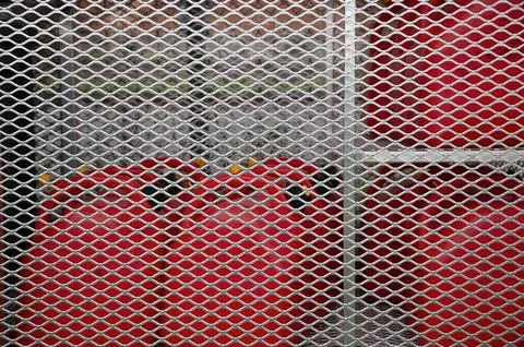Security Grid Protecting Red Gas Tanks Behind Fence Stock Photos