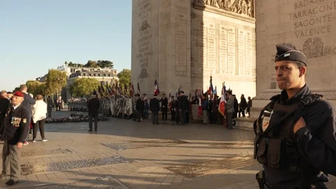 Security guard at Arc de Triomphe overlooking a military ceremony in the sun Stock Footage 220952652