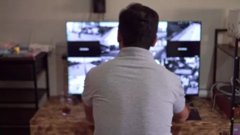 Security guard from behind reviewing CCTV camera footage on twin monitors, Stock Footage 342747881