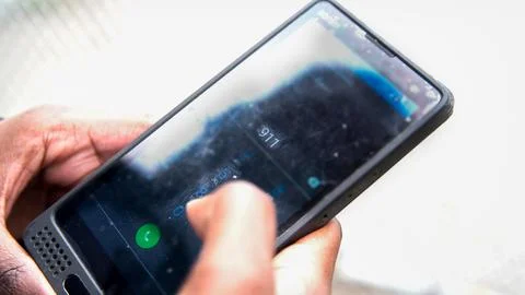 Security guard calling 911 on his black phone. Stockfoto's