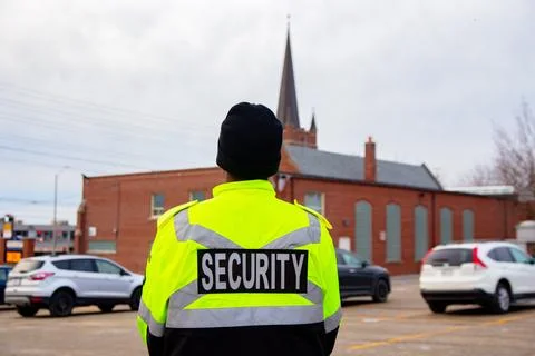 Security guard with caution tape to do parking enforcement at guest parking lot. Stock Photos