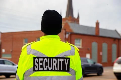 Security guard with caution tape to do parking enforcement at guest parking lot. Stock Photos