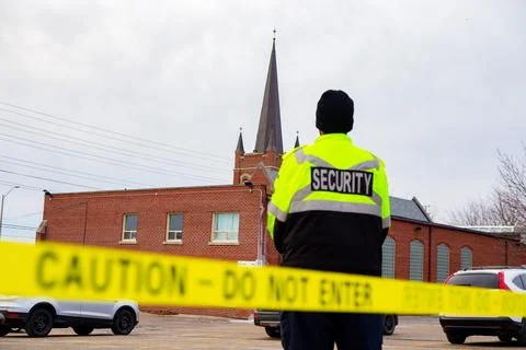 Security guard with caution tape to do parking enforcement at guest parking lot. 库存照片
