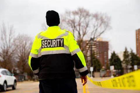Security guard with caution tape to do parking enforcement at guest parking lot. Stockfoto's