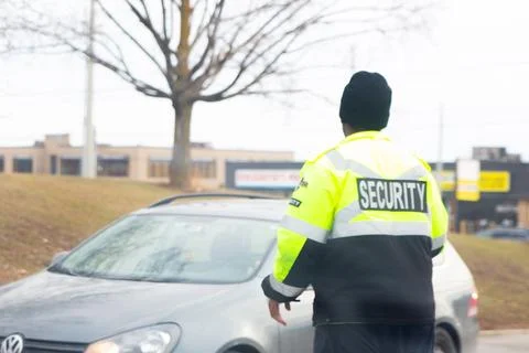 Security guard with caution tape to do parking enforcement at guest parking lot. Stock Photos