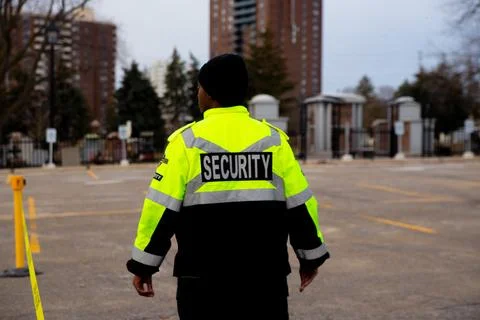 Security guard with caution tape to do parking enforcement at guest parking lot. Stock Photos