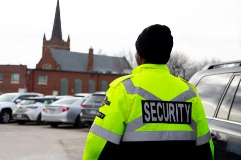 Security guard with caution tape to do parking enforcement at guest parking lot. Stockfoto's