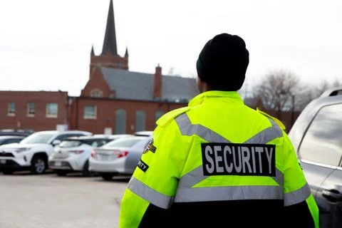 Security guard with caution tape to do parking enforcement at guest parking lot. Stockfoto's