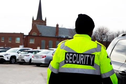 Security guard with caution tape to do parking enforcement at guest parking lot. Stockfoto's