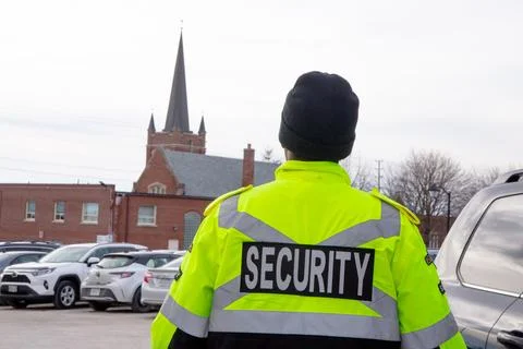 Security guard with caution tape to do parking enforcement at guest parking lot. Stock Photos